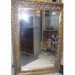 A modern carved giltwood framed wall mirror in the Rococo style Size approx.
