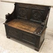 A carved oak box seat hall settle in the Gothic Revival taste,