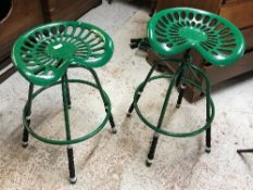 A pair of green painted cast iron "tractor seat" stools