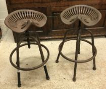 Two cast iron "tractor seat" stools inscribed "William Doyle and Co Ltd"