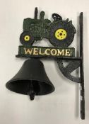 A painted cast metal sign inscribed "Welcome" and decorated with a tractor and bell 32 x 20 cm