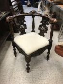 A Victorian carved walnut yoke back corner chair in the 18th Century manner with cherubim and lion