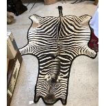A Zebra pelt rug on black felt mount,