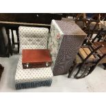 An upholstered nursing chair, leather suitcase, Lloyd Loom linen basket,