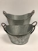 Two large galvanised oval planters 64 cm wide and two smaller to match