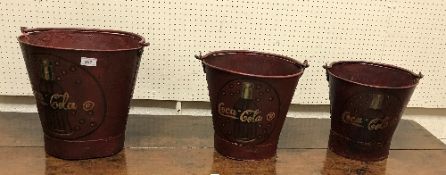 A graduated set of three reproduction "Coca Cola" buckets largest 32 cm high