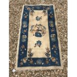 A circa 1920's Chinese carpet, the central panel set with bird and foliate motif on a cream ground,
