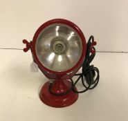 A red tractor headlight style table lamp,