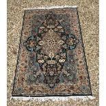 A Persian design rug with centre medallion on a blue black ground,