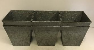 A pair of three joined square tapering planters,