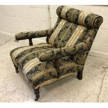 A stained beech framed and upholstered open arm easy chair on carved and turned supports in the