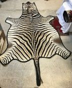 A Zebra pelt rug on black felt mount,