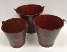 A graduated set of three vintage style painted metal buckets inscribed "Coca Cola" ,