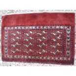 A Bokhara Juval rug with all over stylised medallion decoration on a red ground,