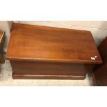 A stained cedar trunk, the plain top over plain sides with wrought iron handles,
