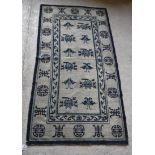 A Chinese rug, the central panel set with repeating Oriental floral motifs on a cream ground,
