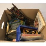 A box containing assorted toys to include various chess pieces, two books on chess,