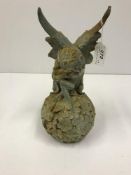 A modern cast iron figure of a fairy seated on a flower ball, approx 32 cm high,