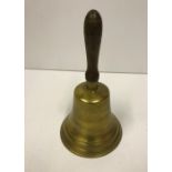 A reproduction brass school hand bell with wooden handle, approx 26.