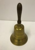 A reproduction brass school hand bell with wooden handle, approx 26.