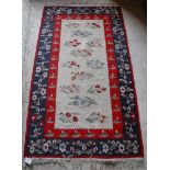 A Kelim rug with cream ground central field decorated with floral sprays,