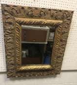 A modern gilt framed rectangular wall mirror with scrolling acanthus decoration in the Rococo taste,