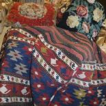 A box containing four various needlework scatter cushions, a carpet scatter cushion,