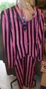 A collection of clothing to include a 1940's/50's pink and black striped trusseau and a black coat,