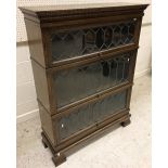 An oak three section bookcase in the Globe Wernicke manner with leaded glazed panels,