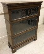 An oak three section bookcase in the Globe Wernicke manner with leaded glazed panels,