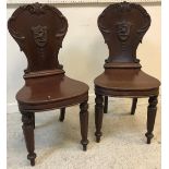 A pair of early 19th Century mahogany panel seated hall chairs,