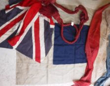 A vintage Union flag together with a navy and cream pennant flag and a length of tricolor material,