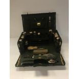 A circa 1900 green dyed leather and gilt lined travelling vanity case with collection of cut glass