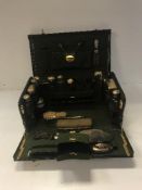 A circa 1900 green dyed leather and gilt lined travelling vanity case with collection of cut glass