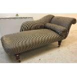 A Victorian upholstered scroll end chaise longue on turned legs to brass caps and castors