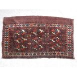 A Bokhara Juval rug with repeating medallion decoration on a plum ground,