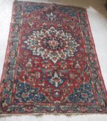 A Caucasian rug with central flower decorated star burst centre medallion on a floral decorated red