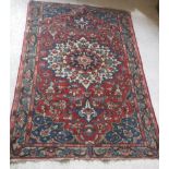 A Caucasian rug with central flower decorated star burst centre medallion on a floral decorated red