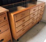 A stained beech and glazed haberdasher's counter with twelve show drawers and glazed front, 138.