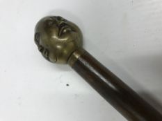 A modern walking stick with Buddha head decoration to top