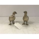 A pair of modern hollow silver figures of grouse naturalistically modelled as a male and female