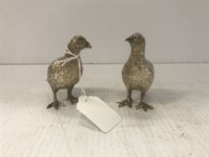 A pair of modern hollow silver figures of grouse naturalistically modelled as a male and female