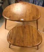 A graduated pair of Ercol elm pebble tables of typical form,