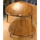 A graduated pair of Ercol elm pebble tables of typical form,