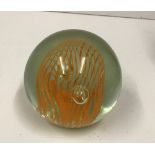 A modern paperweight with orange internal swirl decoration,