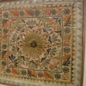 An Indian needlework panel with stylised flower head decoration to centre and applied mirrored