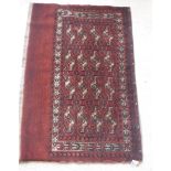 A Bokhara Juval rug with all over stylised medallion decoration on a red ground,