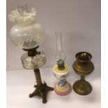 A circa 1900 brass Corinthian column oil lamp set with flowers raised on paw feet with vaseline