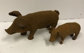 A small modern cast iron pig ornament, approx 30 cm long, together with a larger version,