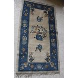 A circa 1920's Chinese carpet, the central panel set with bird and foliate motif on a cream ground,